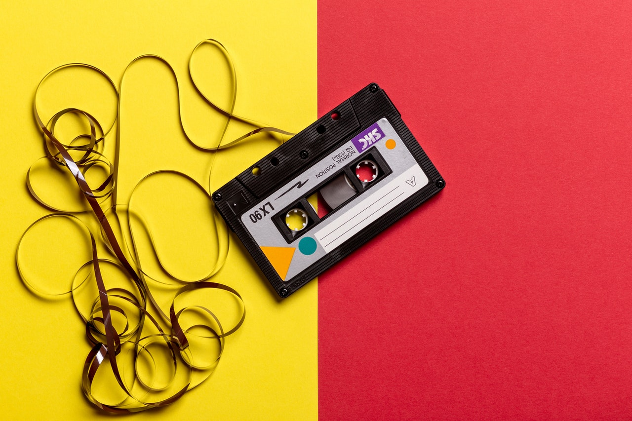 black-cassette-tape-on-top-of-red-and-yellow-surface