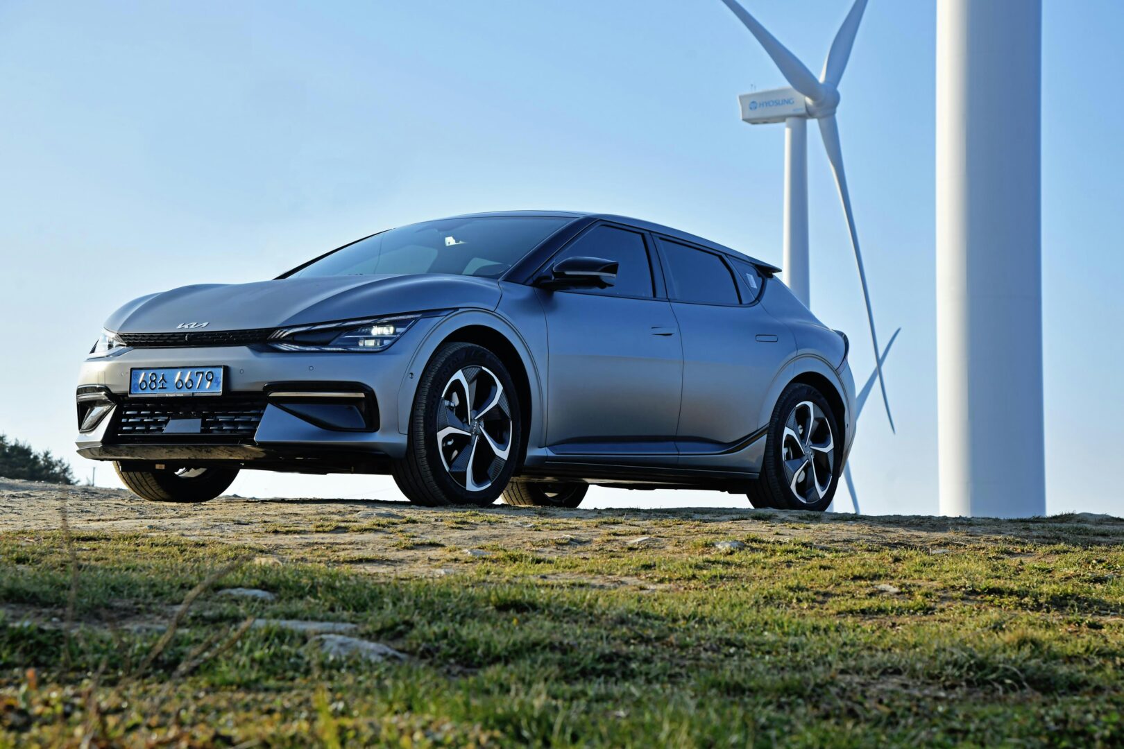Electric Kia car under wind turbines