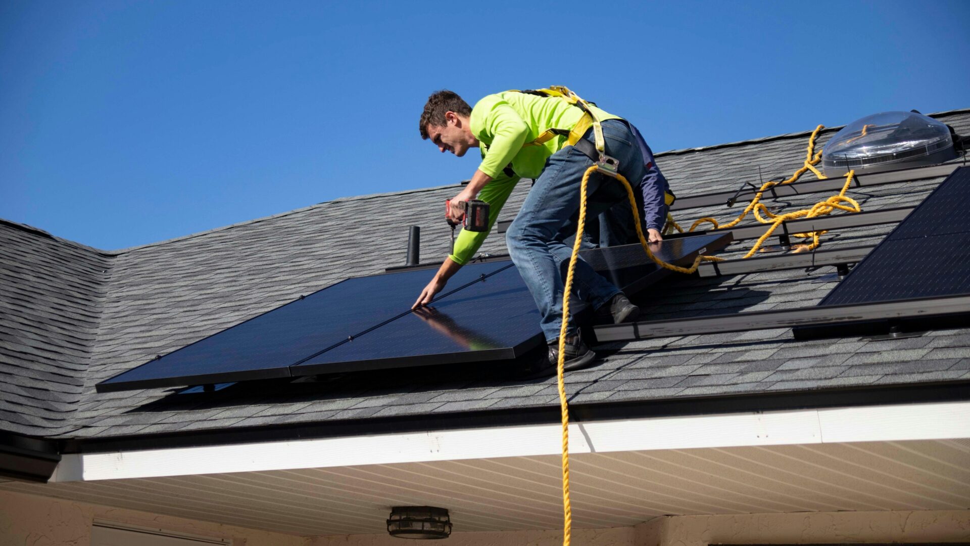 Maintenance worker installing solar panels on a roof.