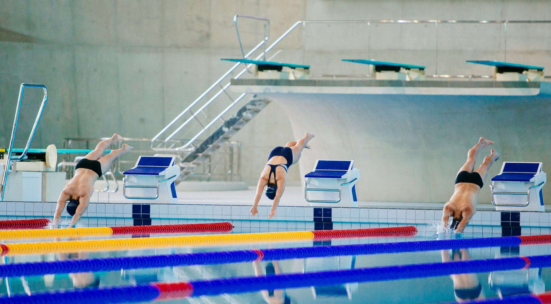 Photograph of swimmer diving into a pool.