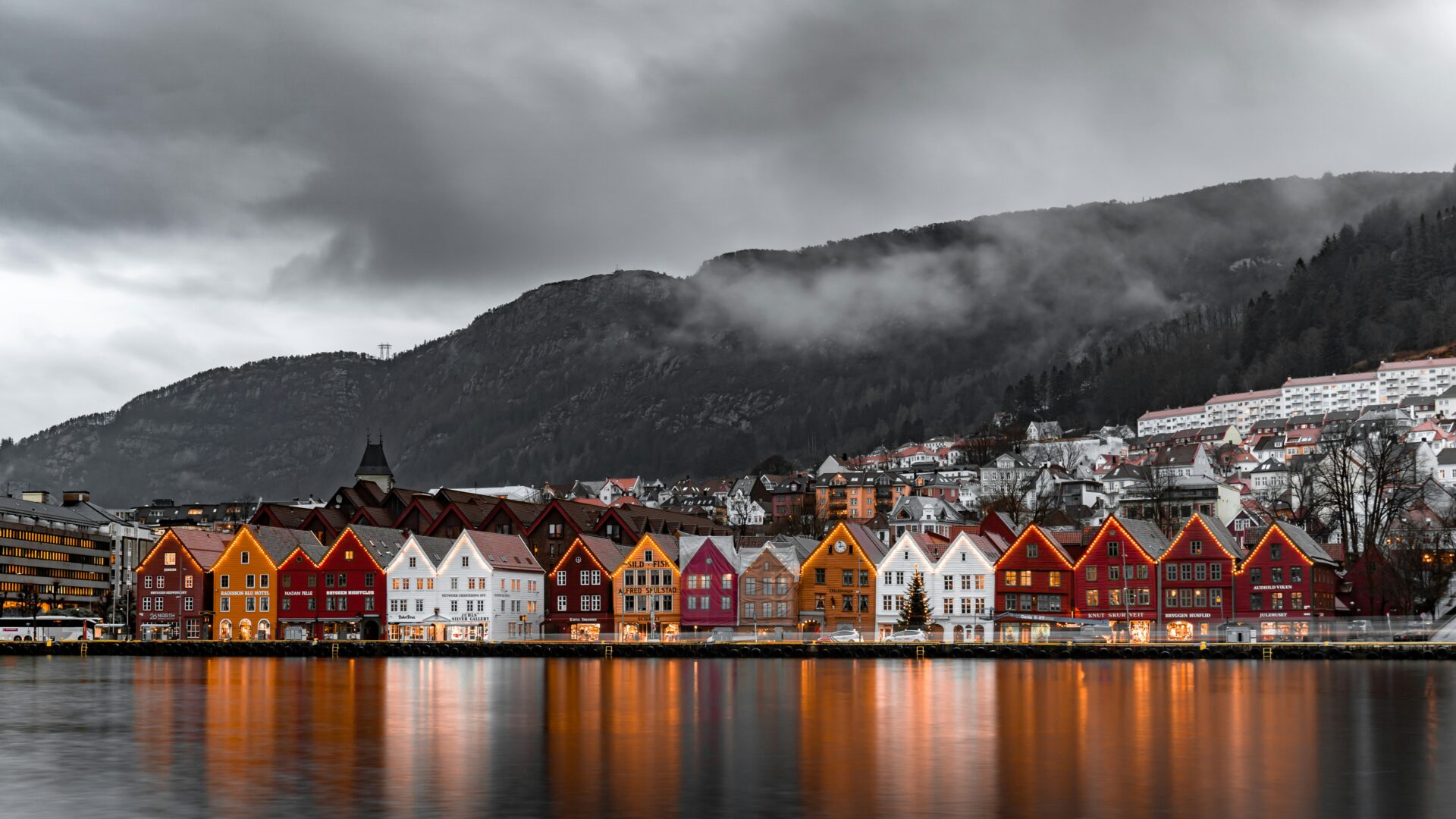 Far away view of colourful houses on the edge of a lake on a cloudy day