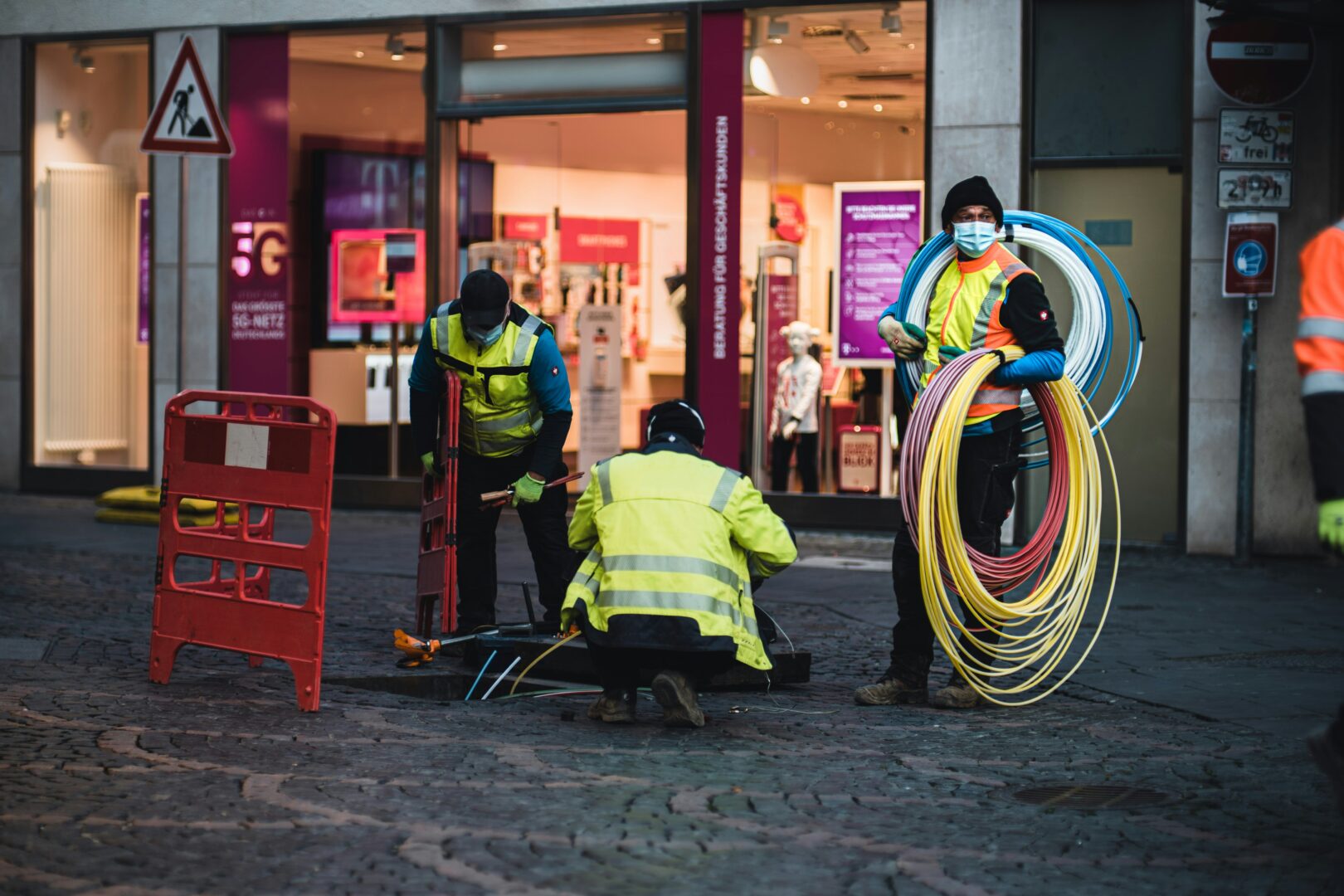 Photo of workers laying down broadband lines in front of a business