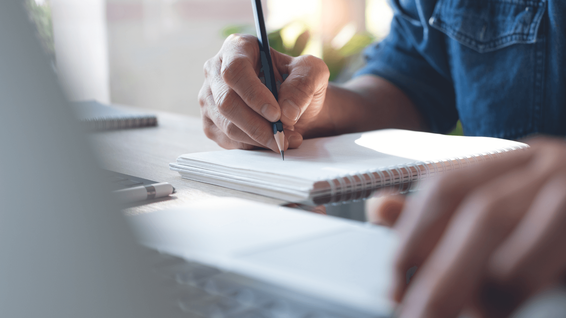 Man Writing On Notebook
