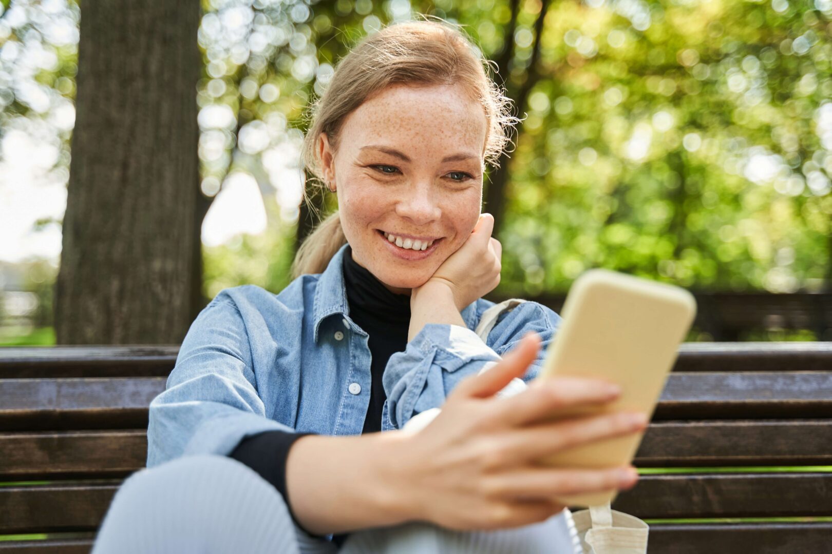 happy young women outside using phone