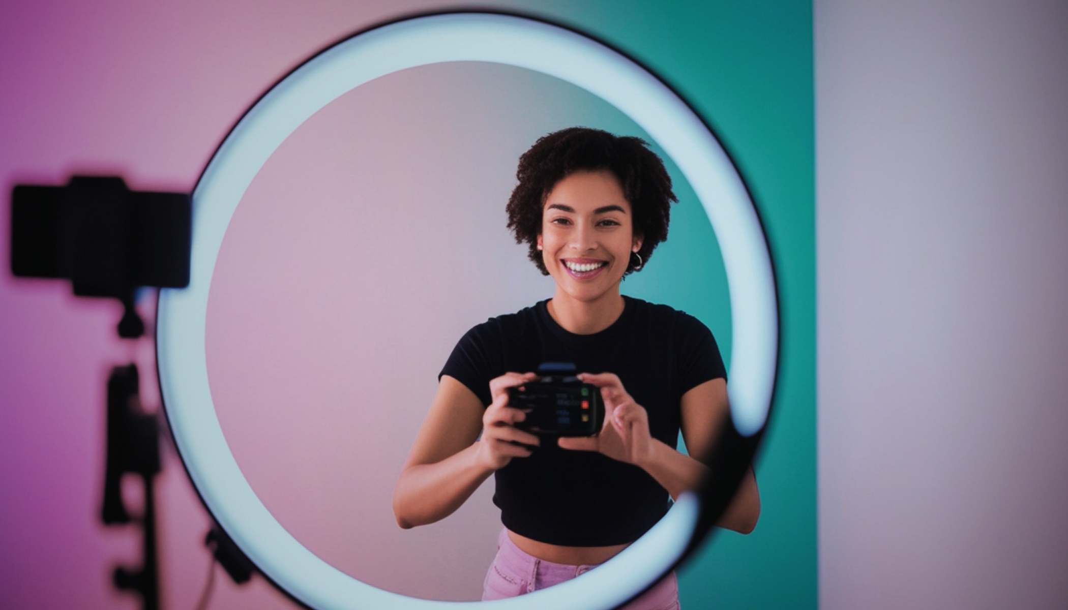A journalist filming vertical video content on a smartphone in a modern newsroom, representing the growing shift toward creator-style journalism and influencer-led media strategies.