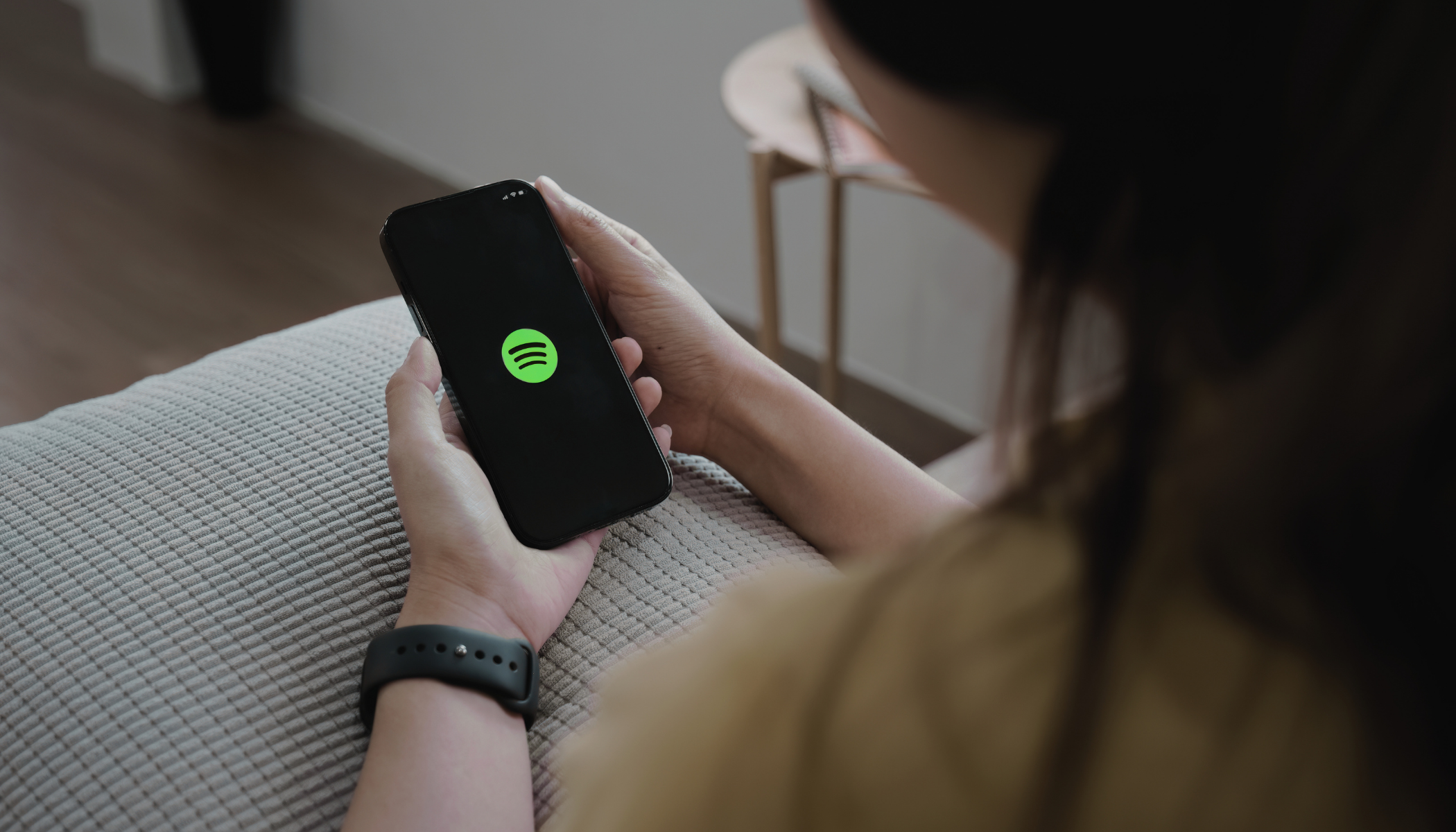 A person with the Spotify app open, representing Spotify's new AI-powered podcast discovery feature that generates personalised listening queues from natural language prompts.
