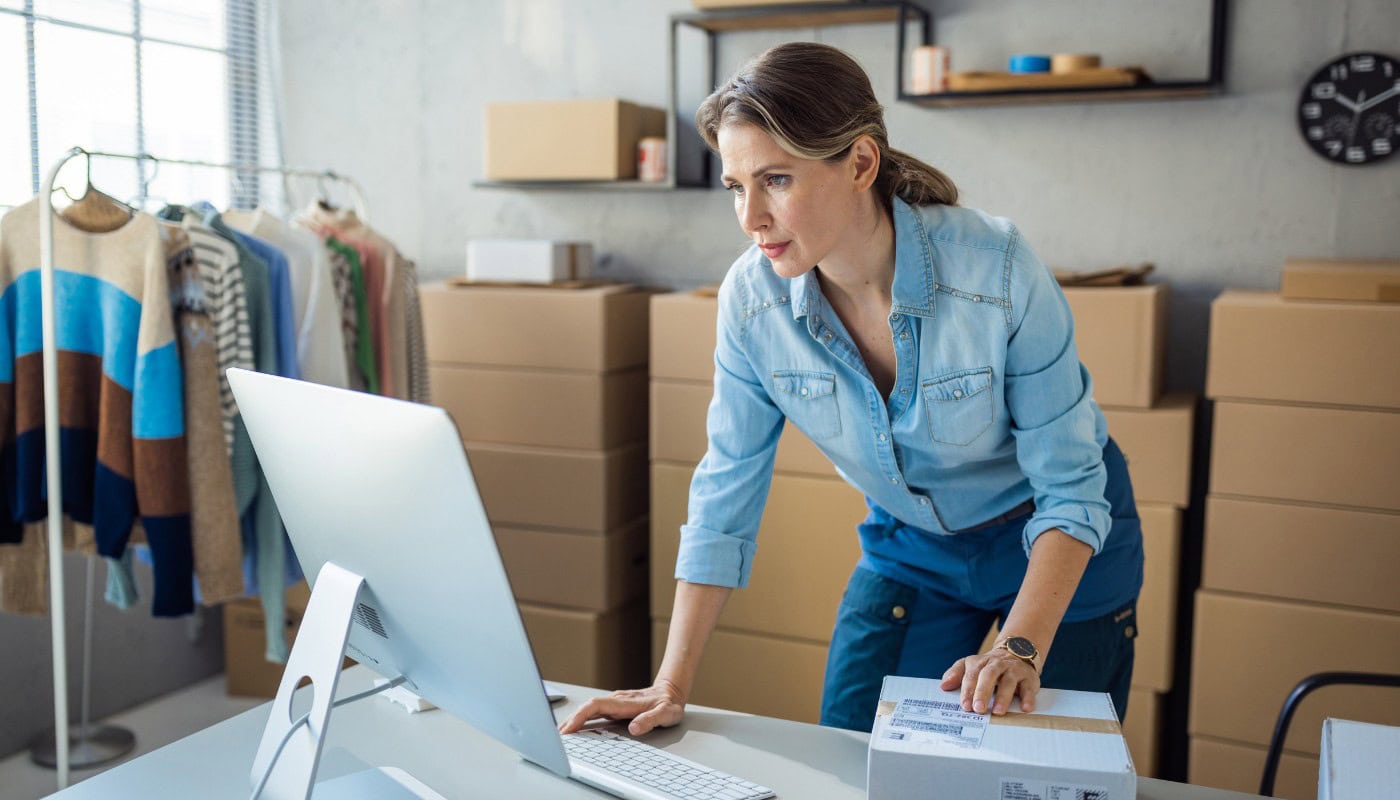 A small business owner working at a desk surrounded by receipts and paperwork, representing the rising cost pressures facing US small businesses in 2026 despite cooling headline inflation figures.